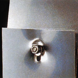 Adhesives reduce stress concentration at screw and rivet points. Image of failing mechanical fastened overlap shear joint.