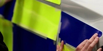 Person applying reflective sheeting to a police car
