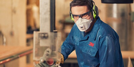 Worker wearing maintenance free respirator and Peltor ear muffs
