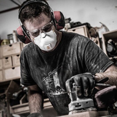 Worker wearíng hearing protection, eyewear and mainenance free respirator